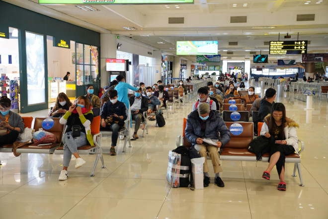 Hành khách ngồi tại phòng chờ sân bay quốc tế Nội Bài - Ảnh: Phan Công