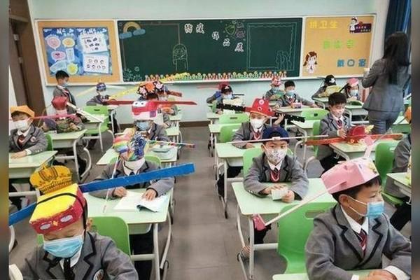 Học sinh đội “chiếc mũ 1 m” khi ngồi trong lớp. (Ảnh: Weibo)