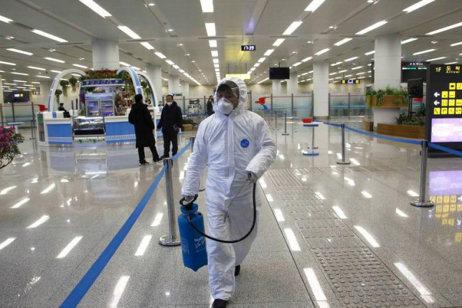 Nhân viên Ủy ban Nhà nước về Quản lý
chất lượng mang dụng cụ xịt khử trùng đi kiểm tra và kiểm dịch
người và hàng hóa nhập khẩu, tại sân bay Bình Nhưỡng, ngày 1-2.
Ảnh: AP