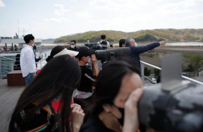 Du khách mang khẩu trang quan sát
sang Triều Tiên từ tỉnh Paju (Hàn Quốc) ngày 26-4. Ảnh: AP