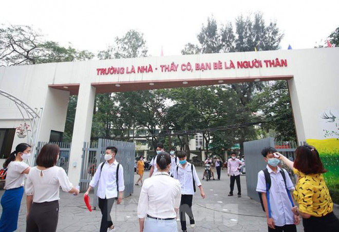 Học sinh đeo khẩu trang, chào cờ tại lớp học trong ngày đầu trở lại trường - 1