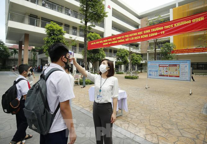 Học sinh đeo khẩu trang, chào cờ tại lớp học trong ngày đầu trở lại trường - 2