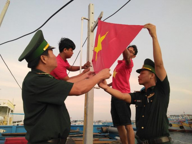 Lực lượng Biên phòng huyện Phú Quý trao cờ từ Chương trình "Một triệu lá cờ Tổ quốc cùng ngư dân bám biển" - Ảnh: Kỳ Nam