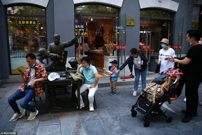 Ngồi chờ trước một cửa hàng ăn uống ở thành phố Bắc Kinh.