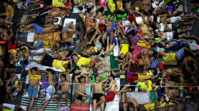 Các phạm nhân ngủ ngoài trời tại nhà tù TP Quezon ở Manila (Philippines). Ảnh: REUTERS