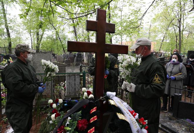 Người thăm viếng tại nơi chôn cất mục sư Andrei Molchanov, 54 tuổi, ở Nga vào ngày 9-5. Ông Molchanov chết vì nhiễm Covid-19. Ảnh: Reuters