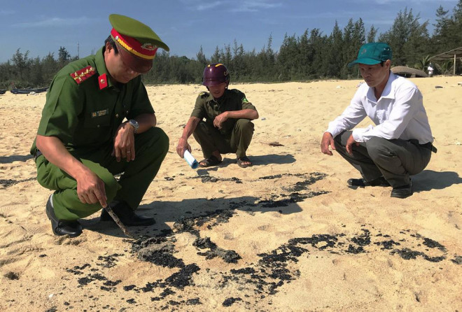 Lực lượng chức năng huyện Mộ Đức lấy mẫu chất bẩn. Ảnh: T.Trực