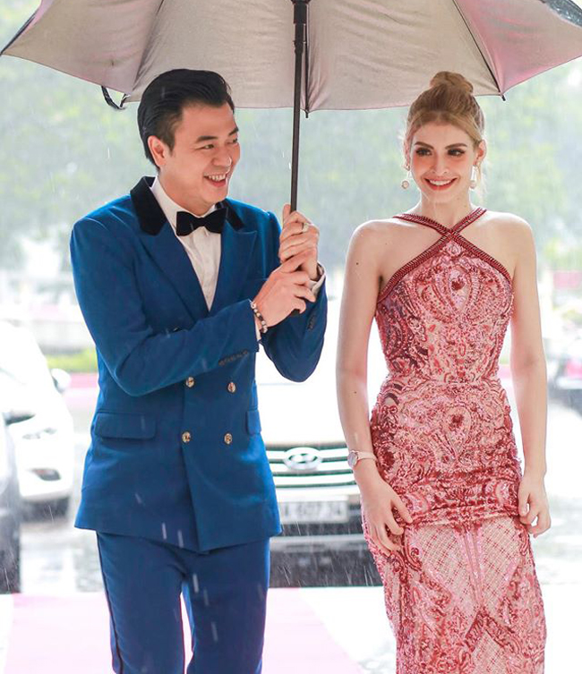 Andrea được MC Tuấn Tú che mưa khi cùng dự sự kiện vào tháng 8 năm ngoái. Cô trở lại với showbiz trong hình ảnh của một khách mời.
