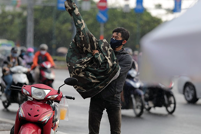 &nbsp;Chiều 16/5, cơn mưa bất ngờ ập đến khiến nhiều người vội tấp vào lề đường để mặc áo mưa