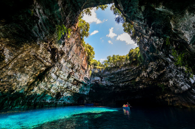 Melissani, Hi Lạp: Nằm trên hòn đảo Kefalonia, hang động Melissani chia làm hai phần. Phần động mở có giếng trời trên đỉnh giúp ánh sáng lọt vào bên trong, phần động còn lại rất tối và được bao phủ bởi rêu, tảo và măng đá.
