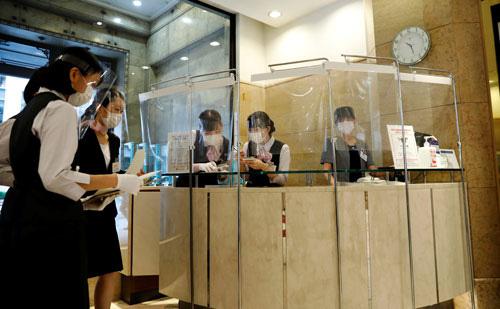 Nhân viên tại một trung tâm mua sắm mới mở cửa lại ở thủ đô Tokyo - Nhật Bản hôm 18-5 Ảnh: REUTERS