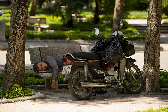 Một người đi đường chọn vườn hoa Công đoàn làm nơi nghỉ ngơi giữa trưa.