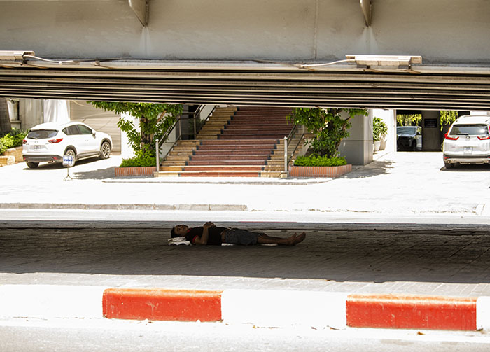 Một người lao động chọn gầm cầu vượt Láng Hạ làm chỗ chợp mắt vào buổi trưa.