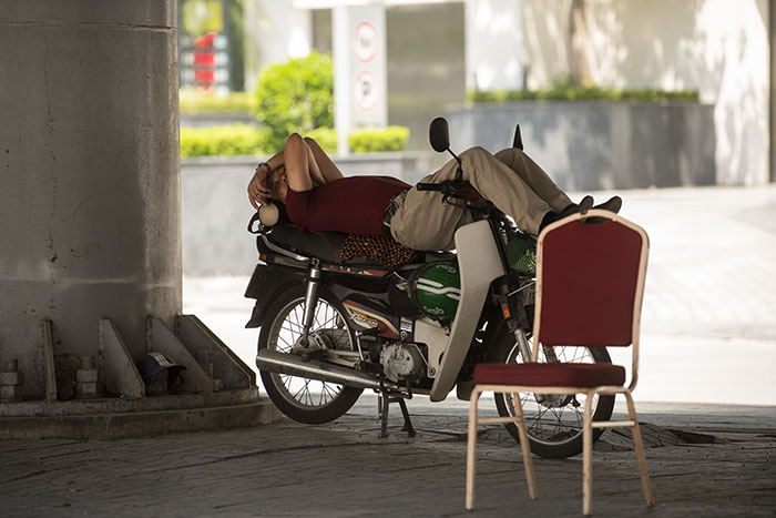 Một bác chạy xe ôm truyền thống cũng chọn gầm cầu vượt làm chỗ ngủ trưa