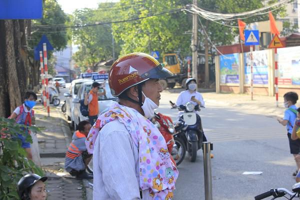 Mang theo mũ, áo chống nắng chờ học sinh tan học.