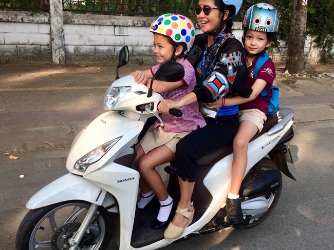 Sau khi ly hôn chồng ngoại quốc, ca sĩ Hồng Nhung lái xe máy đưa hai con đi học.
