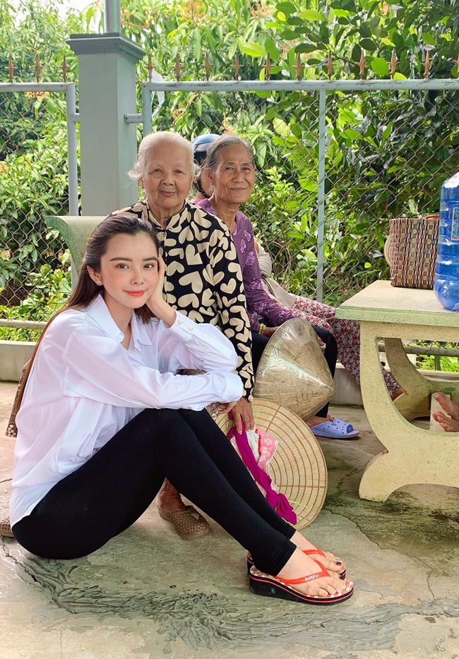 Huỳnh Vy thoải mái ngồi dưới nền gạch, chụp ảnh kỉ niệm cùng các bậc trung niên cao tuổi. Cô nhận được nhiều lời khen với hình ảnh bình dị, nhiệt tình mỗi khi đi từ thiện.
