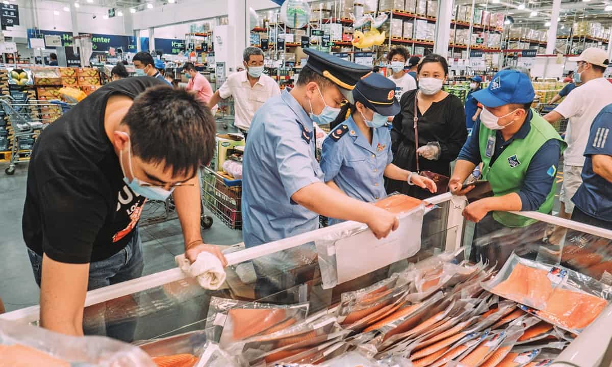 Các nhân viên Cục quản lý Thực phẩm và Dược phẩm Trung Quốc kiểm tra một cửa hàng bán cá hồi tại Bắc Kinh hôm 13/6. Ảnh: GT