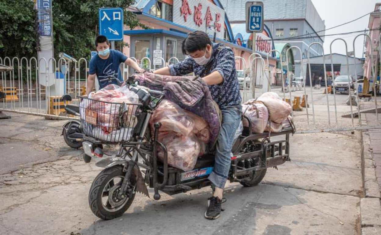 Một người đàn chở thịt ở gần khu chợ Tân Phát Địa, ổ dịch Covid-19 mới ở thủ đô Bắc Kinh, Trung Quốc. Ảnh: EFE