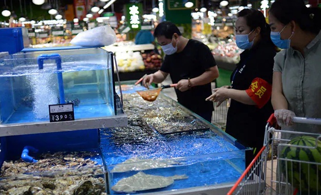Khách hàng chọn hải sản tại một khu chợ ở Bắc Kinh.