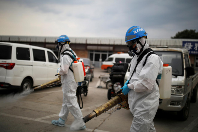 Tình nguyện viên phun thuốc khử trùng tại Bắc Kinh – Trung Quốc hôm 18-6 Ảnh: REUTERS