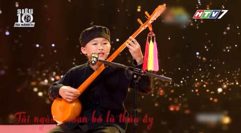 Cậu bé Nguyễn Lô Nhuận biểu diễn đàn tính trên sân khấu