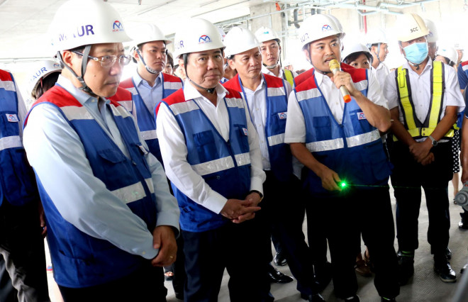 Phó Thủ tướng Phạm Bình Minh (bìa trái) cùng Chủ tịch UBND TP.HCM Nguyễn Thành Phong nghe Trưởng Ban Quản lý đường sắt đô thị Bùi Xuân Cường thuyết minh về dự án metro số 1 sáng 29-6