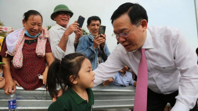 Ông Vương Đình Huệ dành thời gian thăm hỏi các cháu nhỏ khi về dự lễ thông xe cầu Cửa Hội bắc qua sông Lam, nối hai tỉnh Nghệ An- Hà Tĩnh.