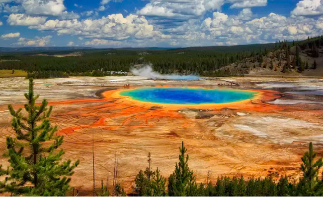 Grand Prismatic Spring ở Wyoming, Mỹ: Grand Prismatic Spring nổi bật với những đám mây trắng bồng bềnh trên bầu trời. 
