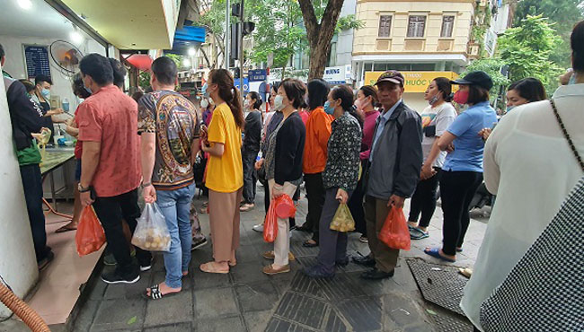 Đoàn người cứ thế không ai bảo ai chia làm 2 hàng dài, một hàng mua bánh chay và một hàng mua bánh trôi.
