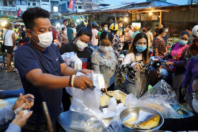 Người dân đeo khẩu trang đổ xô đi mua hàng tại một khu chợ trước lệnh phong tỏa thủ đô Phnom Penh - Campuchia hôm 14-4 Ảnh: Reuters