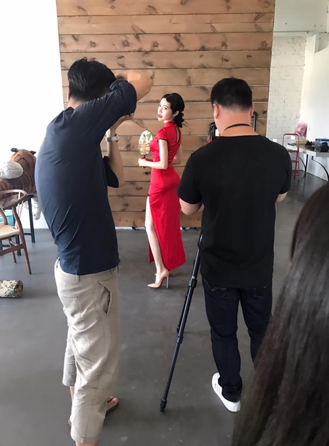 Elly Trần mặc sườn xám đỏ, khoe đường cong quyến rũ trước ống kính.
