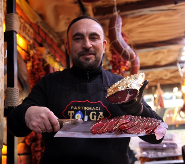 Tolga Korkutoglu, chủ cửa hàng Pastirmaci Tolga gói thịt bò đã qua chế biến được bọc trong nhiều lớp vàng lá có thể ăn được. 
