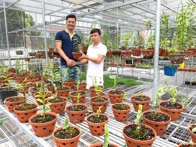 Anh Quyết Tiến (áo trắng) tại vườn lan của mình