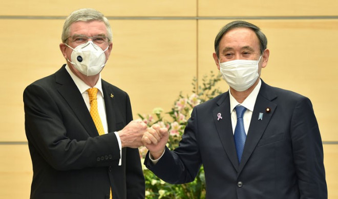 Chủ tịch IOC Thomas Bach (trái) và Thủ tướng Nhật Suga đang trong thế "tiến thoái lưỡng nan". Ảnh: AFP