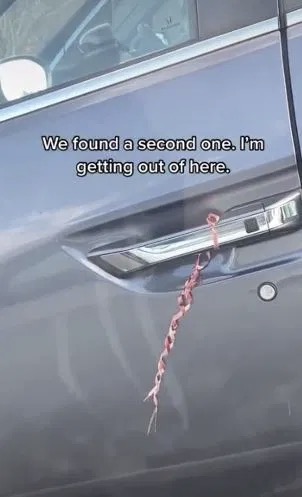 Một chiếc xe ở Mỹ bị buộc sợi dây màu đỏ ở tay nắm cửa.