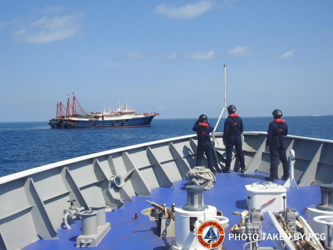 Thành viên Lực lượng bảo vệ bờ biển Philippines (PCG) theo dõi một số tàu nghi là tàu dân quân Trung Quốc trên biển Đông hôm 27-4Ảnh: REUTERS