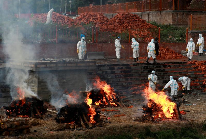 Các công nhân mặc đồ bảo hộ cá nhân đang làm việc để mở rộng lò hỏa táng khi số người chết vì Covid-19 tăng mạnh ở Kathmandu, Nepal. Ảnh: Reuters