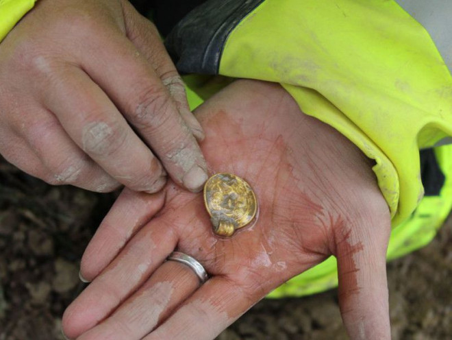 Một trong các mặt dây chuyền khi mới được khai quật - Ảnh: Bảo tàng Lịch sử văn hóa