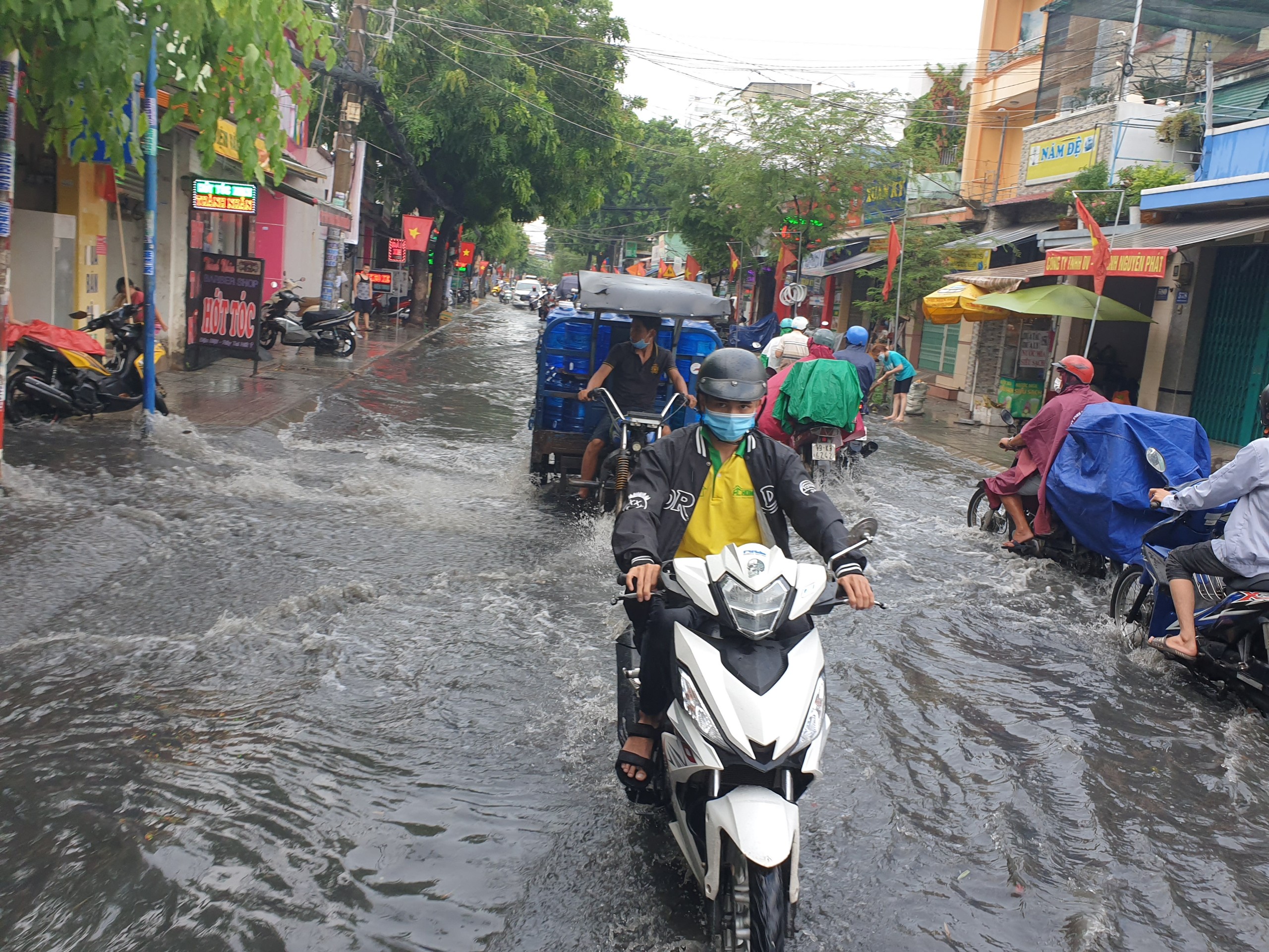 Cụ thể, đường Nguyễn Văn Quá (quận 12) ngập một đoạn khoảng 300m, mực nước ngập hơn 20cm, nhiều phương tiện đi qua khu vực này bị chết máy, người dân buôn bán gặp khó khăn.