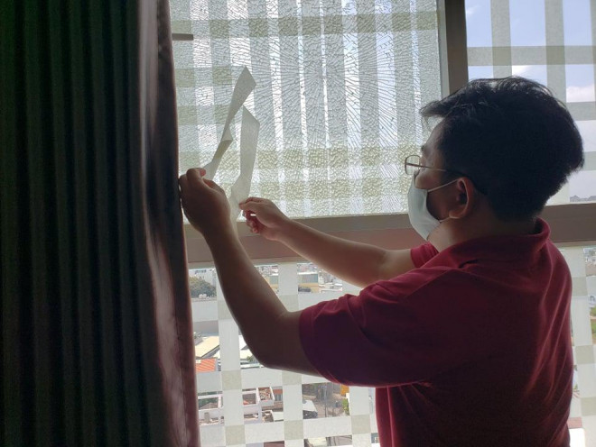 Cư dân thay mới lớp kính bị kẻ gian bắn hư hỏng