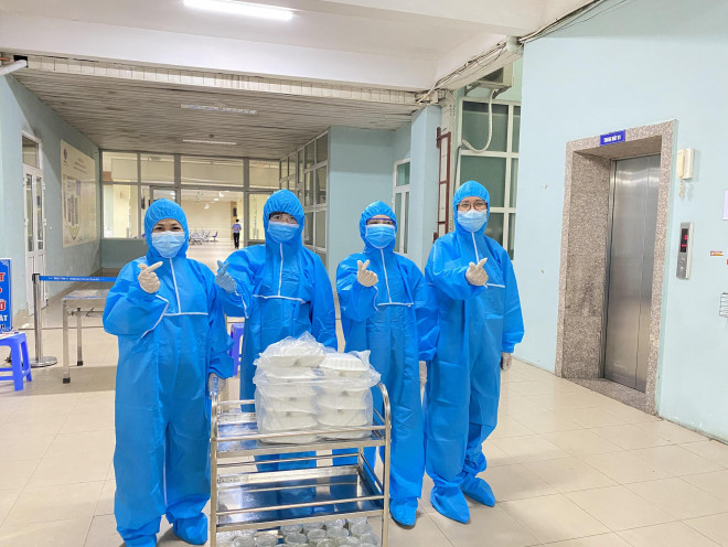 Các nhân viên y tế vận chuyển thức ăn đến bệnh nhân ở Bệnh viện K cơ sở 3.