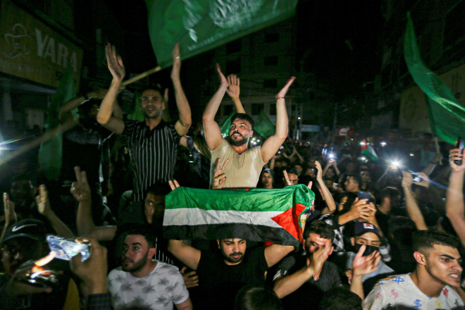 Người dân Palestine đổ ra đường phố ăn mừng ở phía Nam dải Gaza hôm 21-5. Ảnh: REUTERS