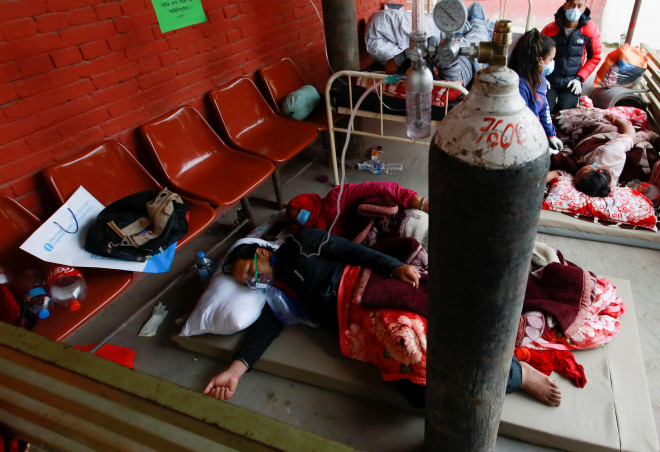 Bệnh nhân được thở oxy trên sàn gần lối đi của bệnh viện do thiếu giường ở thủ đô Kathmandu - Nepal hôm 10-5 Ảnh: REUTERS