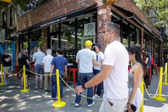 Người dân xếp hàng chờ ăn uống tại một nhà hàng ở TP New York - Mỹ hôm 19-5. Ảnh: REUTERS
