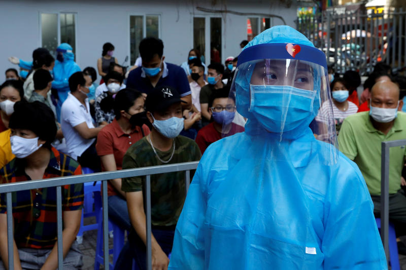 Nhân viên y tế Việt Nam mặc đồ bảo hộ tại điểm xét nghiệm Covid-19. Ảnh: Reuters.