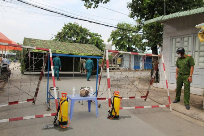 Lực lượng chức năng phong tỏa một địa điểm tại huyện Hóc Môn vì liên quan Covid-19. (Ảnh: HUẾ XUÂN)
