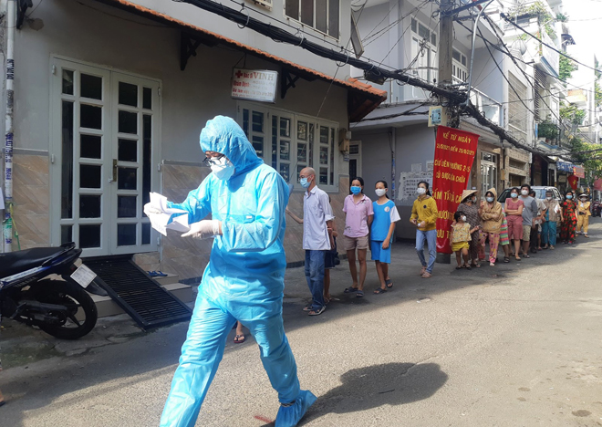 Nhân viên y tế khẩn trương làm thủ tục xét nghiệm cho người dân tại phường 15, quận Bình Thạnh.