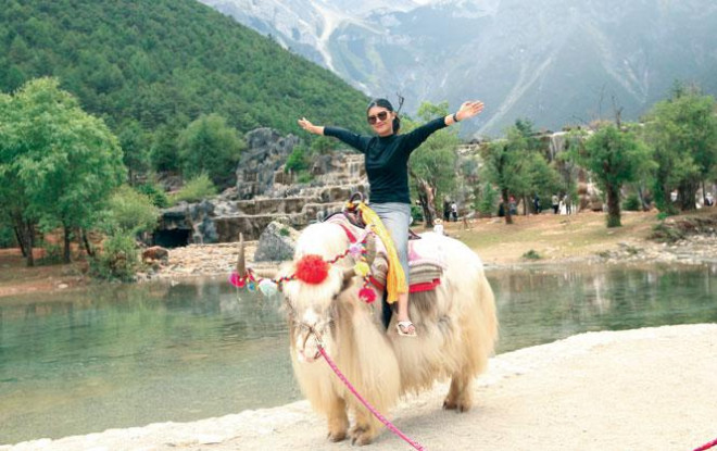 Một người phụ nữ cưỡi bò Tây Tạng ở Lam Nguyệt Cốc.