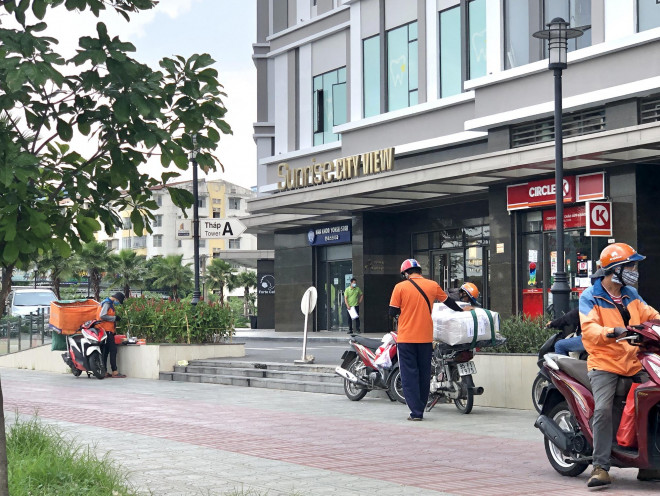 Các shipper đang giao hàng tại một chung cư. Ảnh: Khả Ái